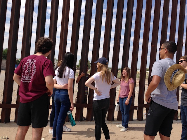Students talk with residents of Mexico at the border fence in Texas.